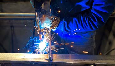 Welding helmet hanging next to company sign